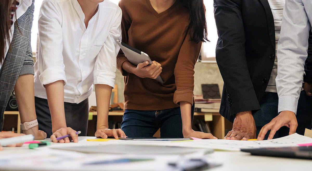 Business leaders work around an office table.