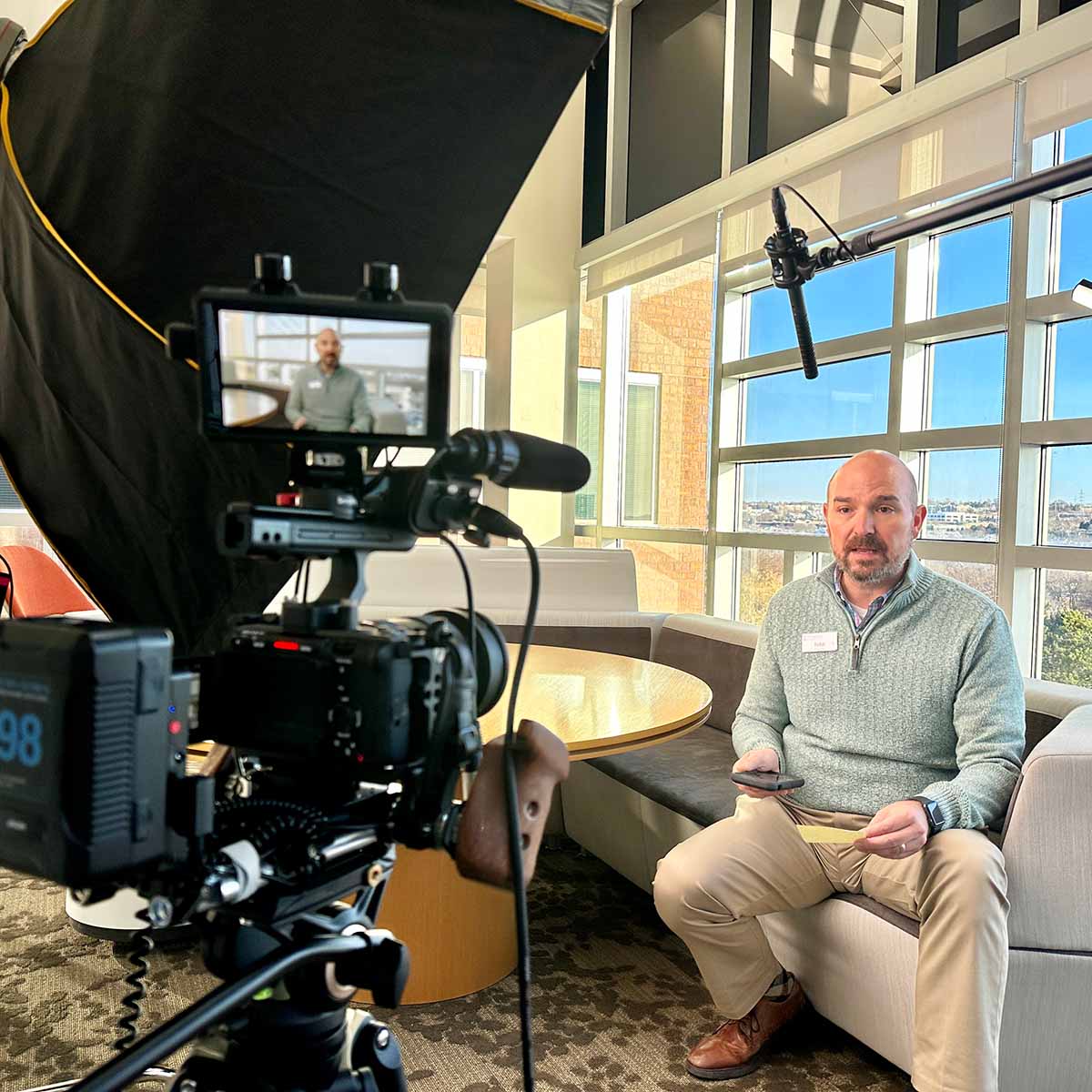 An Immanuel employee presents on camera in office with large windows.