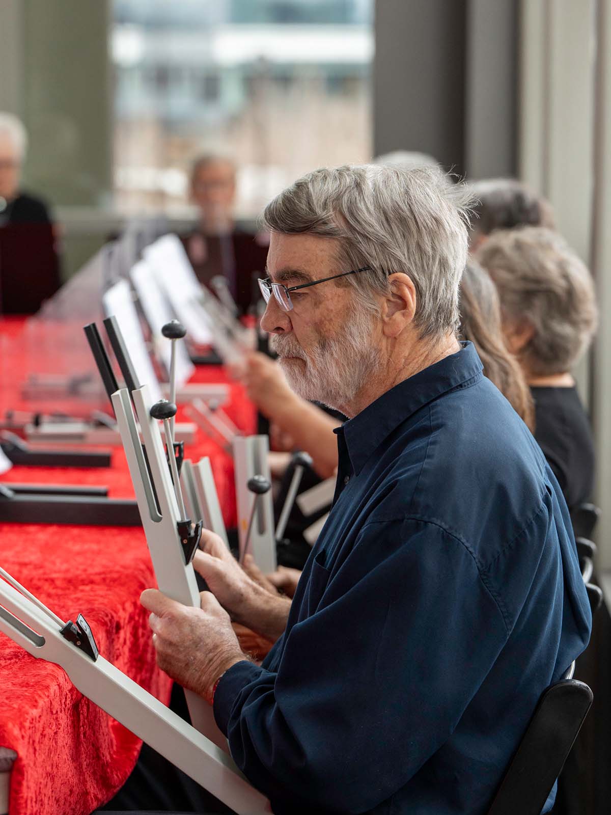 A resident plays a bell instrument during a bell choir performance.