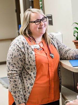Two Immanuel Pathways employees converse near a work station.